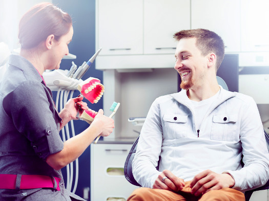 Dentiste avec clients heureux dans salle de traitement de haute technologie